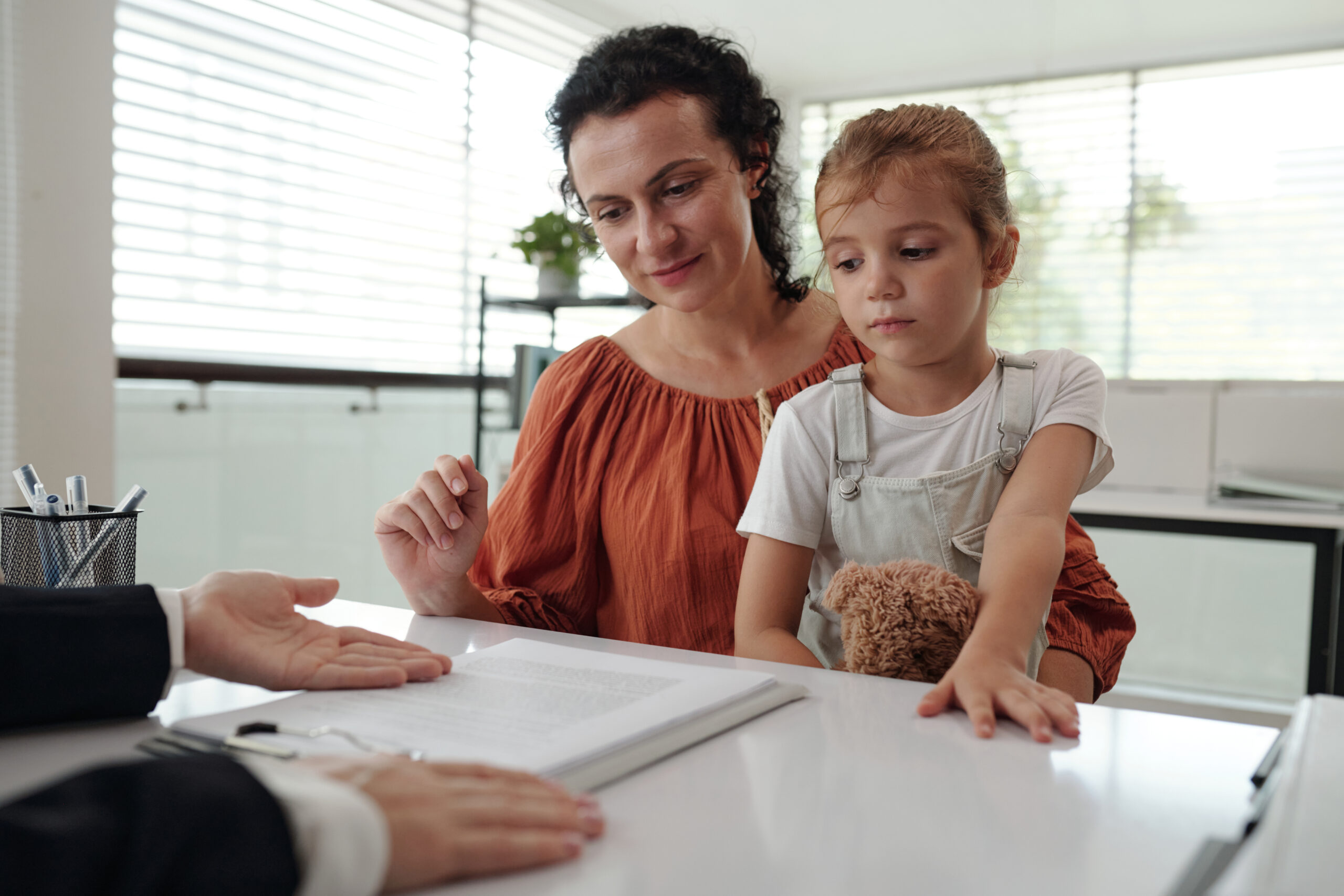 Young Mother Signing Application At Social Service