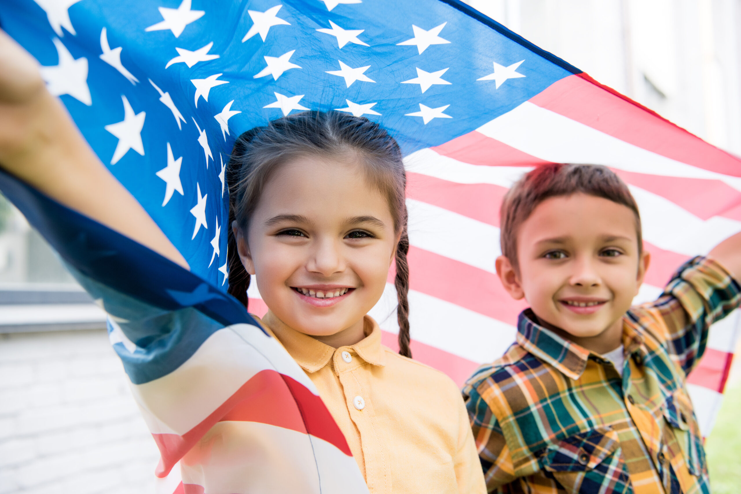 smiling brother and sister with american flag